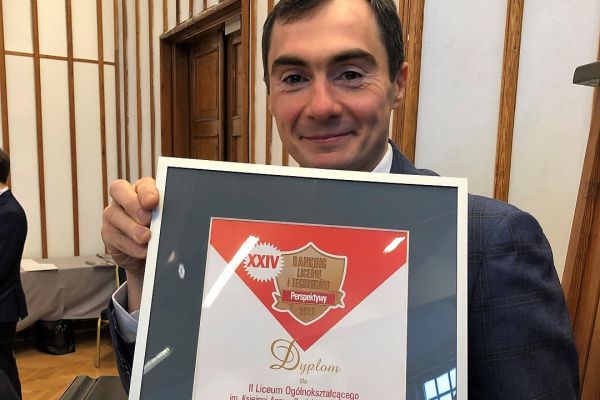 Zdjęcie dyrektora szkoły Dariusza Bossowskiego trzymającego dyplom za zajęcie 1 miejsca w rankingu szkół w województwie podlaskim