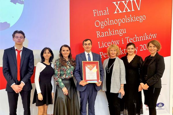 Zdjęcie 7, wsród któych dyrektor szkoły trzyma dyplom