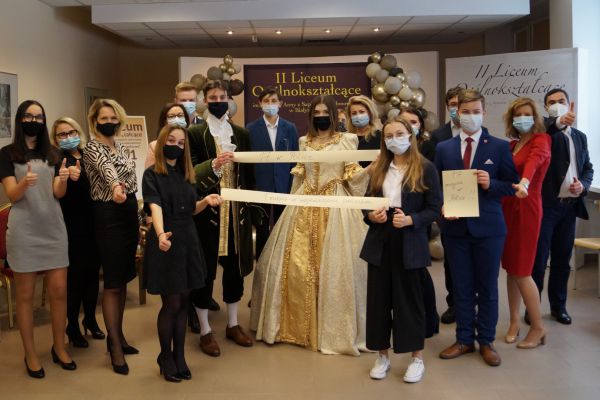 Dyrektor oraz uczniowie z szarfą z wynikami rankingu