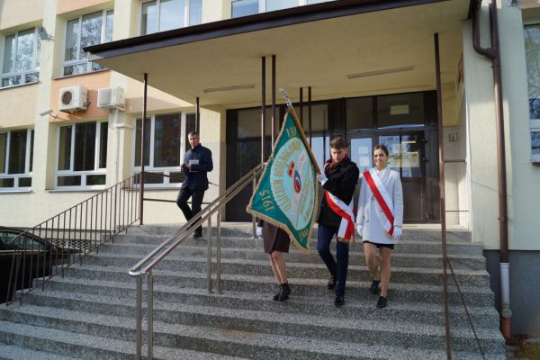 Sztandar Szkoły przed budynkiem szkoły